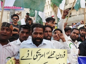 Người dân Pakistan giương khẩu hiệu phản đối cuộc không kích của NATO, hôm 13/12. (Nguồn: Getty Images)